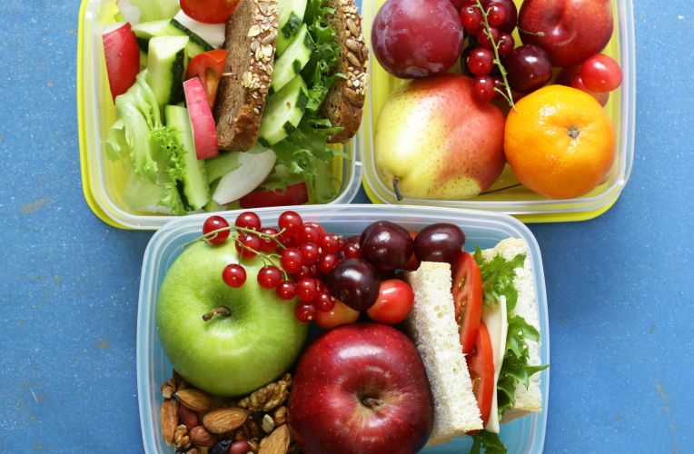 Drei Lunchboxen mit gesundem Essen, Gemüse, Obst und Broten.